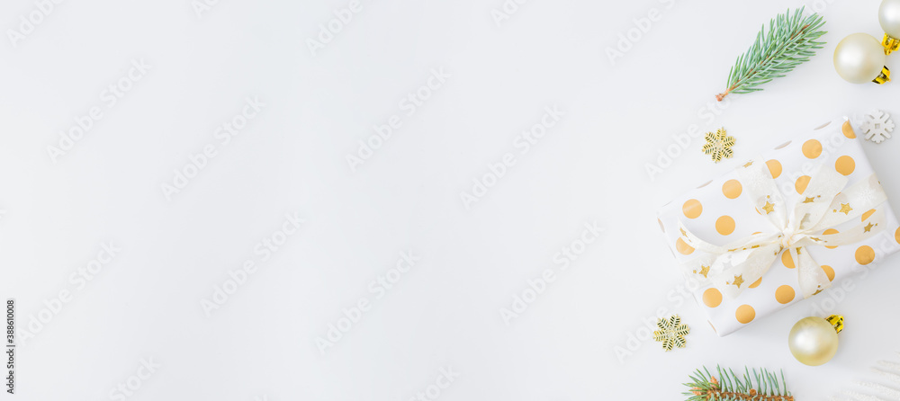 Flat lay frame with fir branches, christmas baubles decoration and gift box on a white background Flat lay frame with fir branches, christmas baubles decoration and gift box on a white background