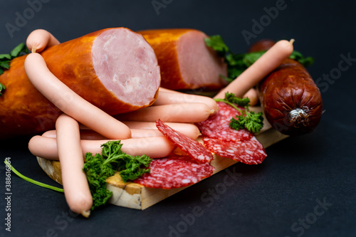 composition of cold cuts on wooden board with different type of cheese