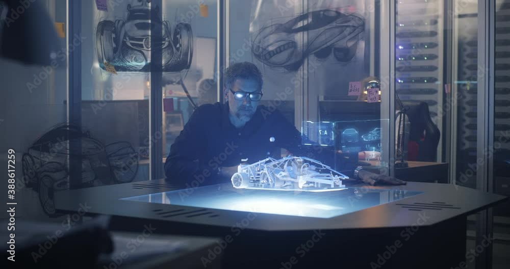 Male engineer using 3D technology to design car