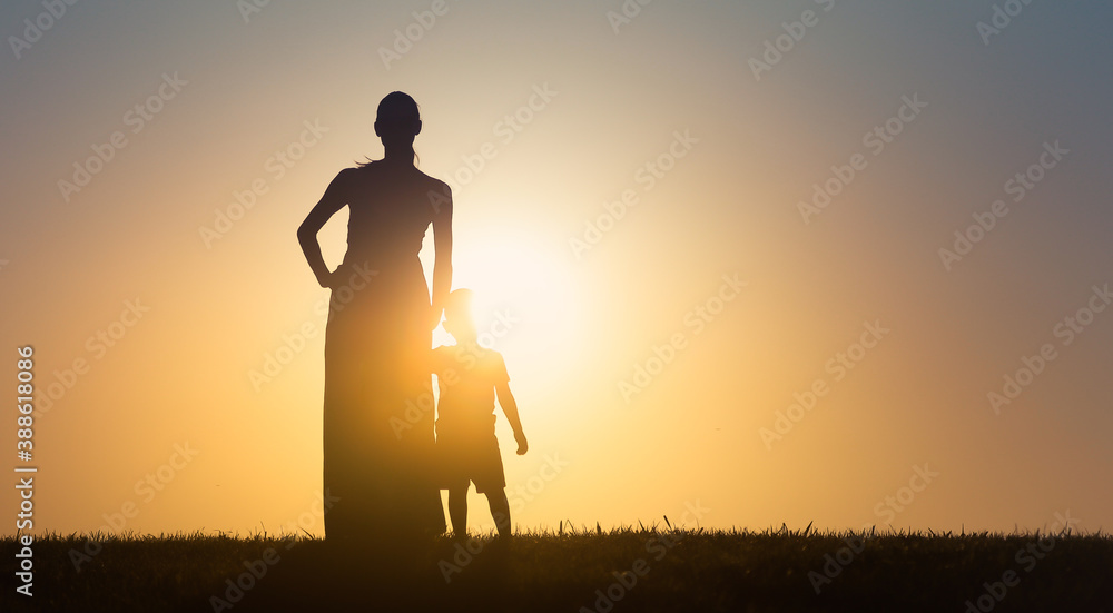 Mother child facing the sunset sky. 
