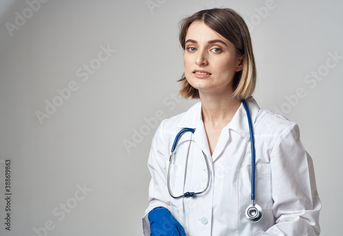 portrait of a nurse in gloves and a medical gown on a light background