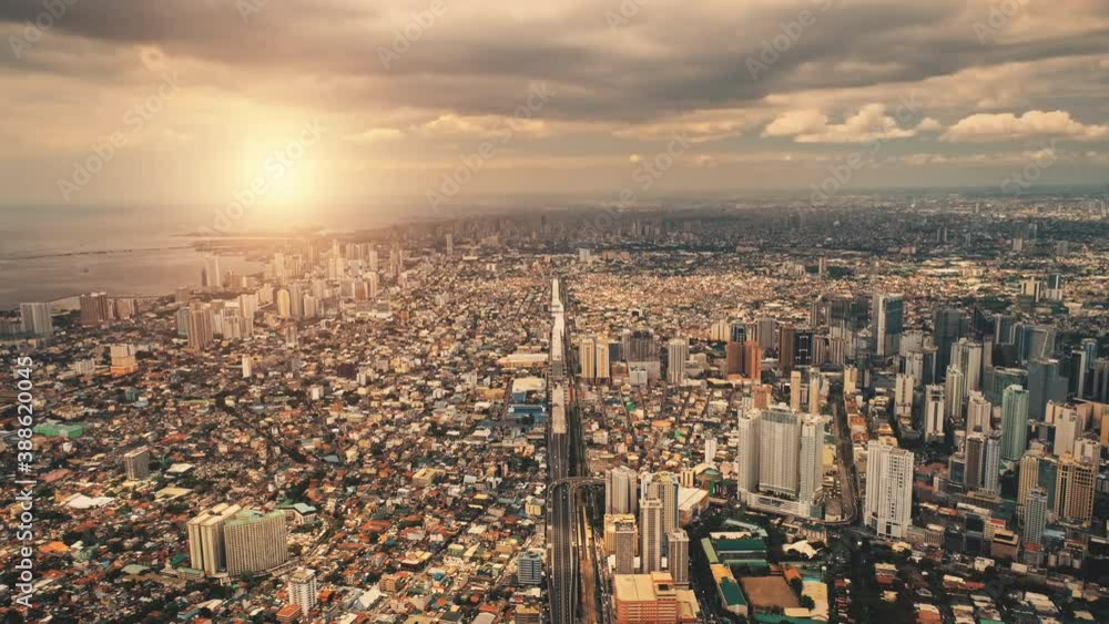 Sun cityscape of port town Manila aerial. Sunrise light over modern buildings, skyscrapers of downtown streets. Metropolis city of Manila, Philippines, Asia. Cinematic highway at summer soft sunlight