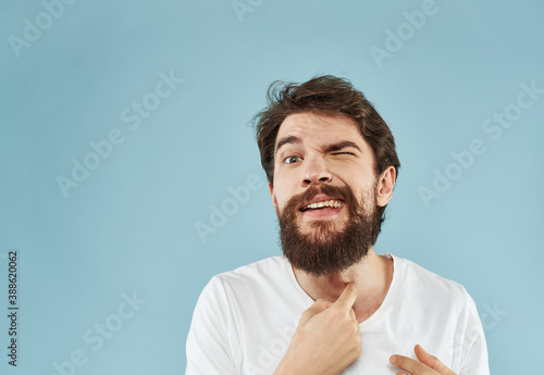 portrait of happy man on blue background in white t-shirt with open mouth emotions © SHOTPRIME STUDIO