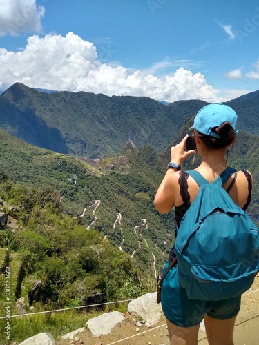 Girl photographing - Sun Gate (Inti Punku) - Machu Picchu - The lost city of the Inca in Peru, South America. Set high in the Andes Mountains, is one of the New Seven Wonders of the World. photo