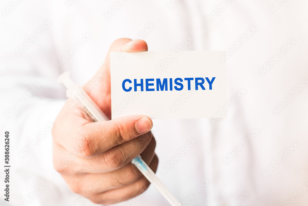 Word chemistry on a white background with a syringe in hand. Medicine concept Word chemistry on a white background with a syringe in hand. Medicine concept