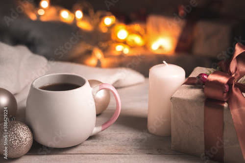Festive background in warm coffee tones with a Cup of coffee and a gift in a cozy Christmas atmosphere. The concept of Christmas and the New year.