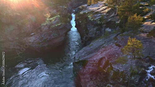 Fast moving water falls and rapids of a glacial river at sunset. 4K aerial video.