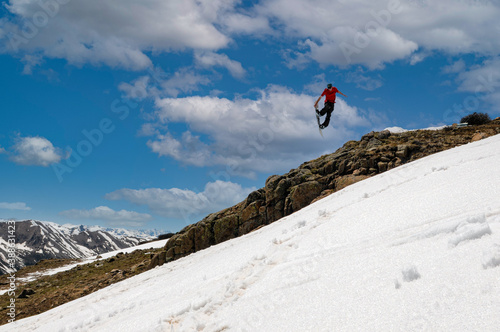 snowboarder jumping in back county late season