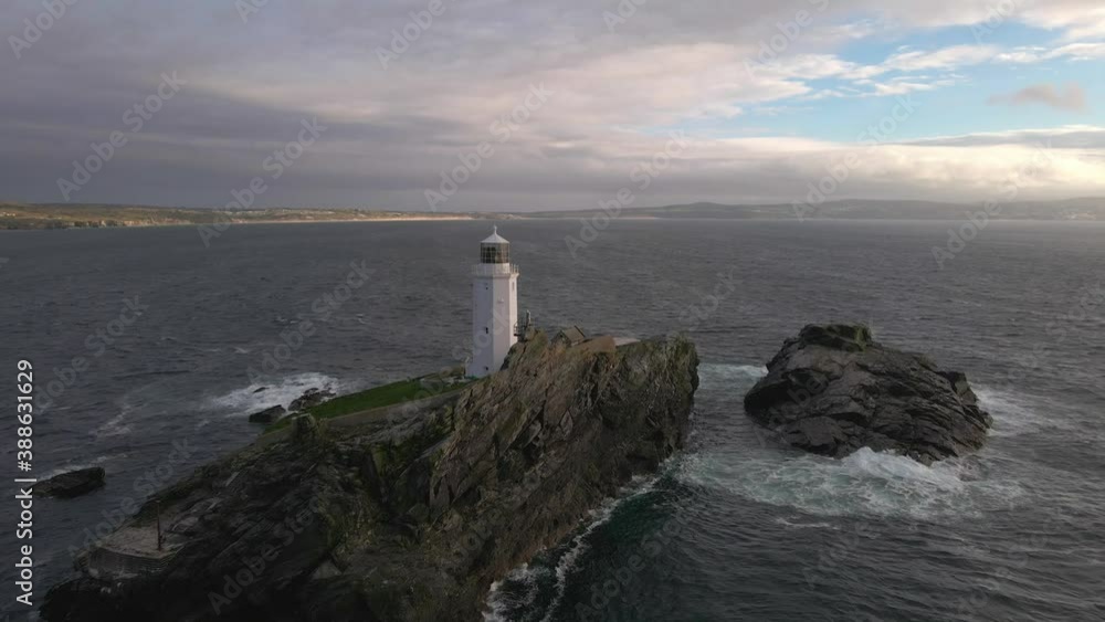 Aerial reveal of a lighthouse on an island in stormy sea Aerial reveal of a lighthouse on an island in stormy sea