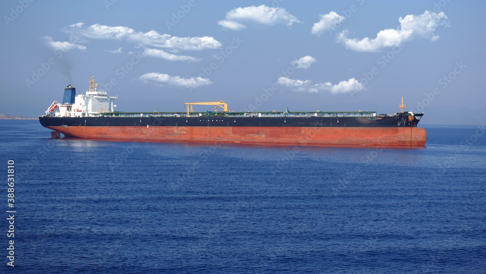 Zoom detail photo of industrial fuel and oil tanker ship anchored in Mediterranean deep blue sea Zoom detail photo of industrial fuel and oil tanker ship anchored in Mediterranean deep blue sea