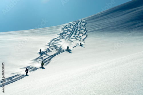 A group of heli skiers come down the mountain
