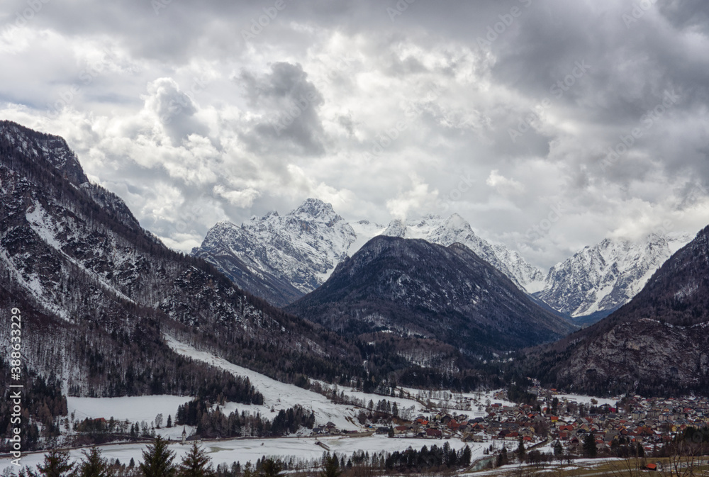 Slovenian Alpine village of Mojstrana on a stormy winters day with Triglav mountains behind