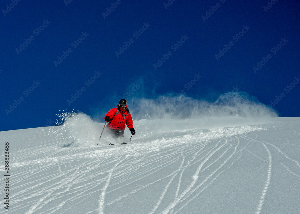 A heli skiing guide skiing fresh snow