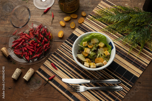 Salad bowl with fork and knife on wooden table