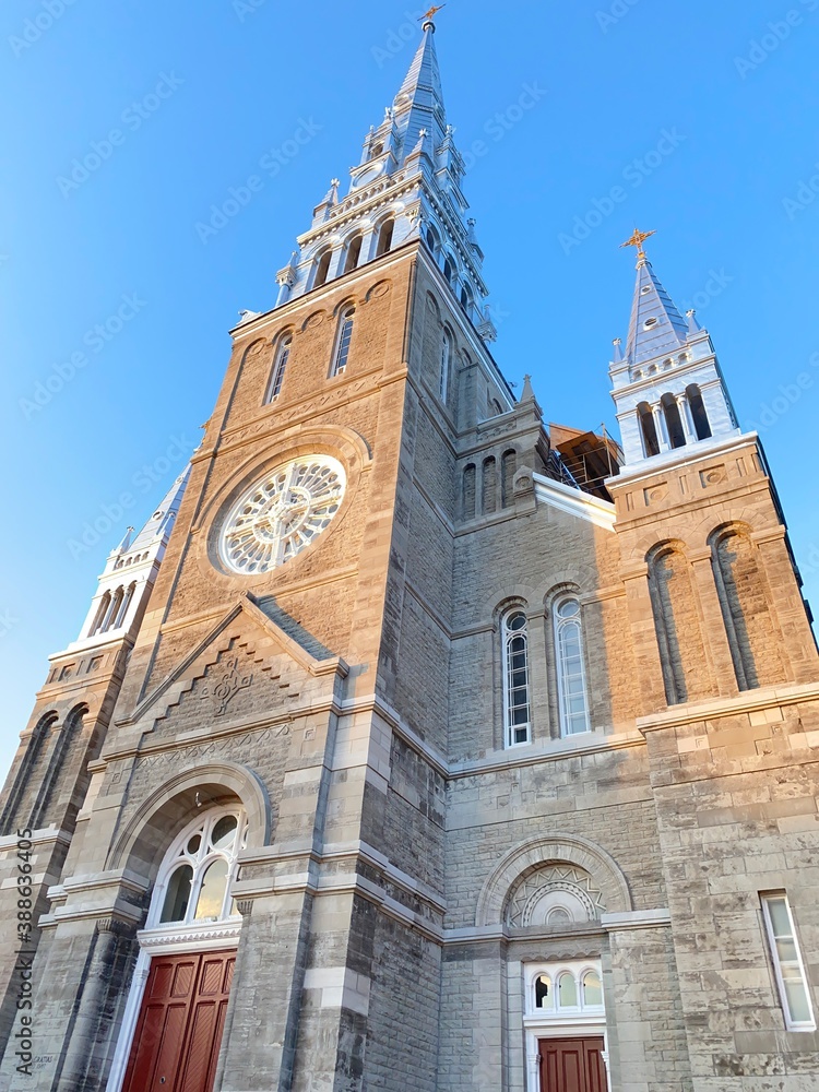 old church with red doors, gables and bell tower in the blue sky