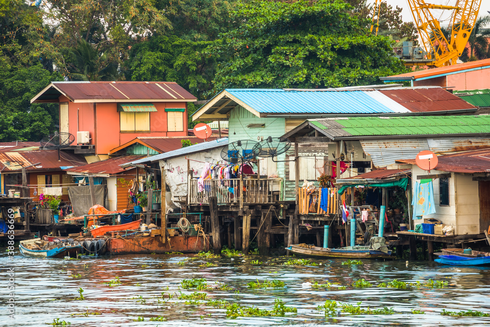 Stilt Houses at a Klong in Bangkok, Thailand. Chao Phraya Riverbank with Lush Vegetation.