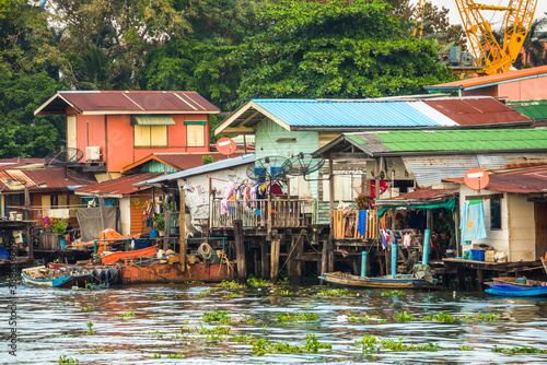 Obraz na płótnie Stilt Houses at a Klong in Bangkok, Thailand. Chao Phraya Riverbank with Lush Vegetation. w salonie
