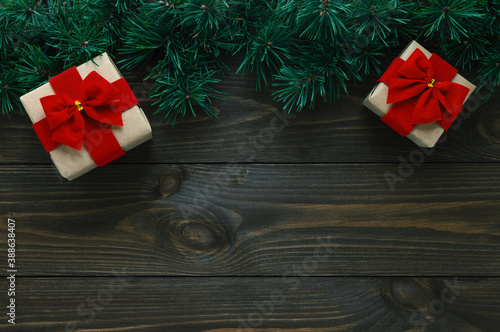 Christmas tree branches and gift boxes on dark wooden background. Christmas card, flat lay, top view, copy space.