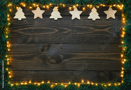 Christmas decoration, christmas lights and fir branches on old wooden background. Flat lay, top view, copy space. © Sasha Kochetkova