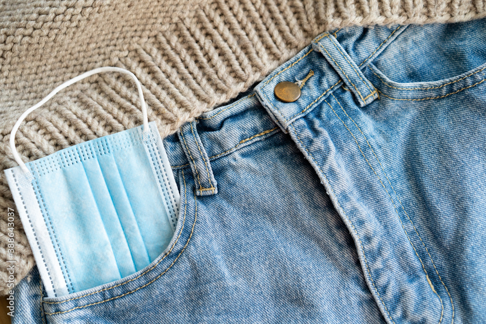 Medical face mask in jeans pocket. The concept of a new lifestyle and fashion after the COVID-19 coronavirus pandemic. Medical face mask in jeans pocket. The concept of a new lifestyle and fashion after the COVID-19 coronavirus pandemic.