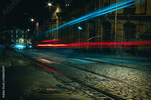 Bild auf Leinwand Empty street at night with with tram rails and long exposure light trails on traditional stone pavement road in Lisbon, Portugal