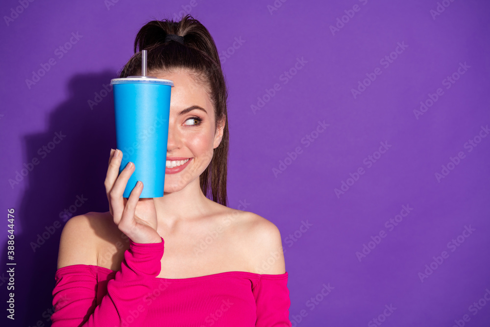 Photo of lovely young lady hold cup close eye look empty space wear jeans pink unclothed shoulders top isolated violet color background