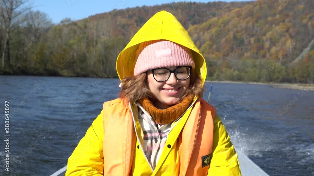 A young girl goes on a Udege boat along the river and looks around. A tourist is riding a boat on the river A young girl goes on a Udege boat along the river and looks around. A tourist is riding a boat on the river