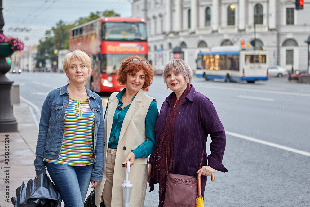 Elderly caucasian female friends stand on street and smile. Elderly caucasian female friends stand on street and smile.