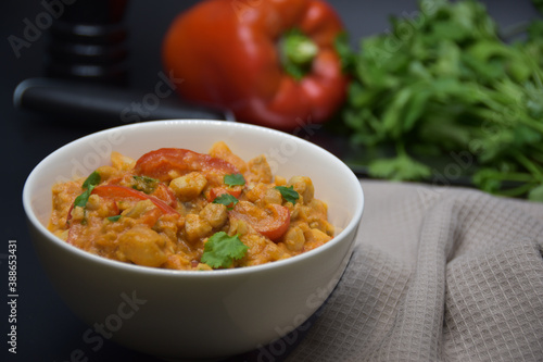 Brazilian fish stew cooked in a delicious, rich and fragrant broth, cilantro, napkin, pepper on a black background. 