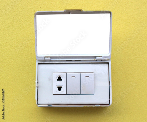 Light switches, light boxes, electrical sockets, 3 electrical outlets on the yellow cement floor beside the wall