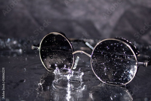Sunglasses with water splashes on a silver background