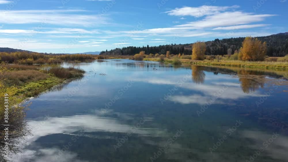 Flying low over glassy pond in Wyoming on sunny day. Flying low over glassy pond in Wyoming on sunny day.