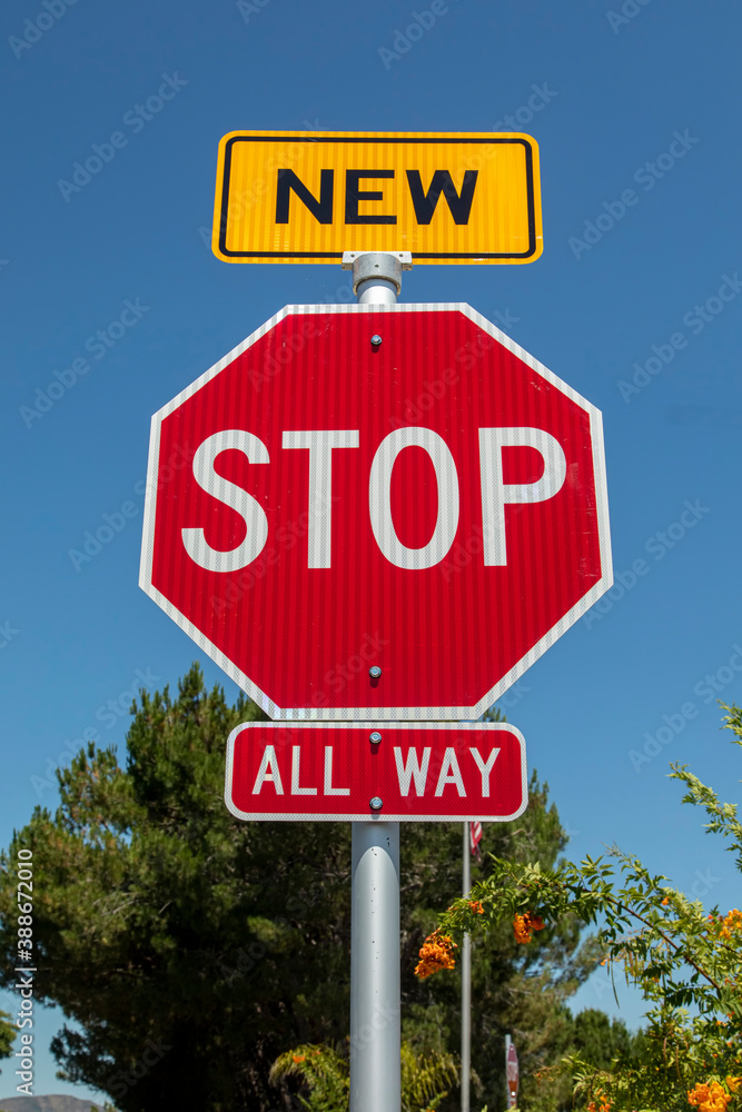 A recently installed stop sign with a small sign in yellow with the word New on top of the stop sign