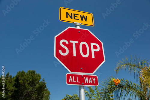 A recently installed stop sign with a small sign in yellow with the word New on top of the stop sign