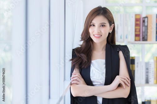 Work from home. Beautiful office lady standing and smiling at work happily.