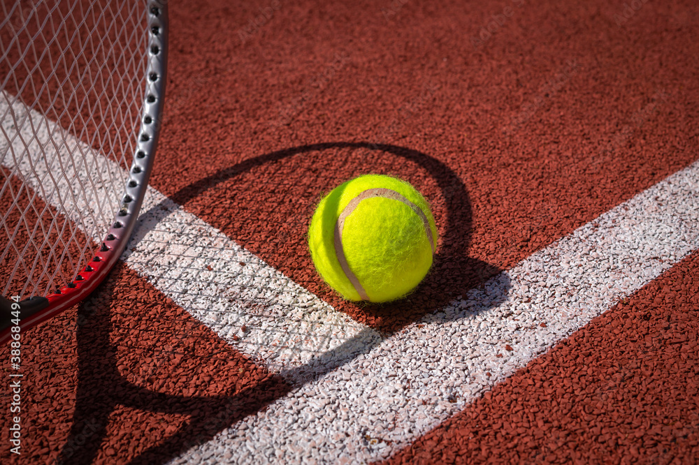 Tennis ball, racket and line on an outdoor court