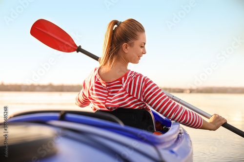Young woman kayaking in river