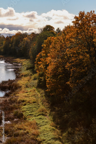 Countryside view of river Venta flowing near forest in autumn.