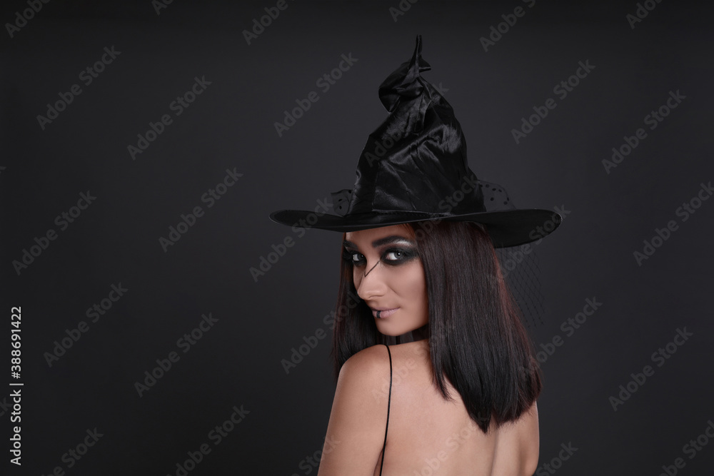 Mysterious witch wearing hat on black background, space for text Mysterious witch wearing hat on black background, space for text