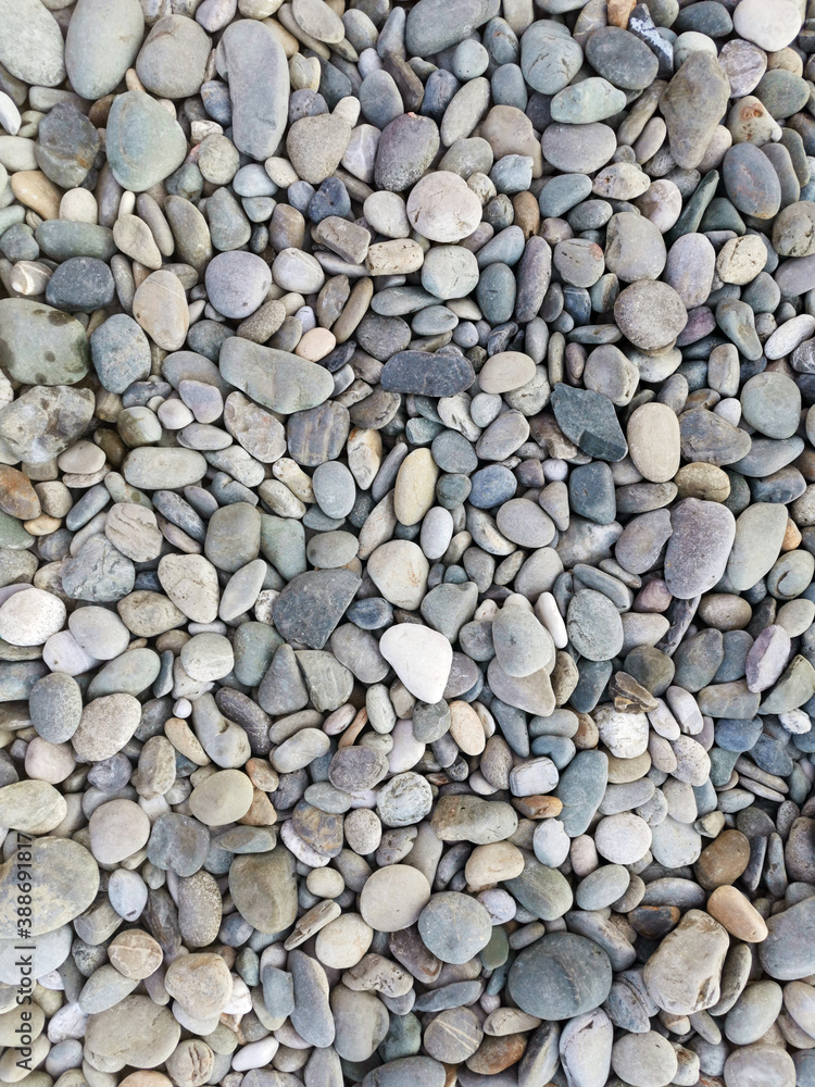 Multicolored smooth stones by the sea, top view. Abstract background. Multicolored smooth stones by the sea, top view. Abstract background.