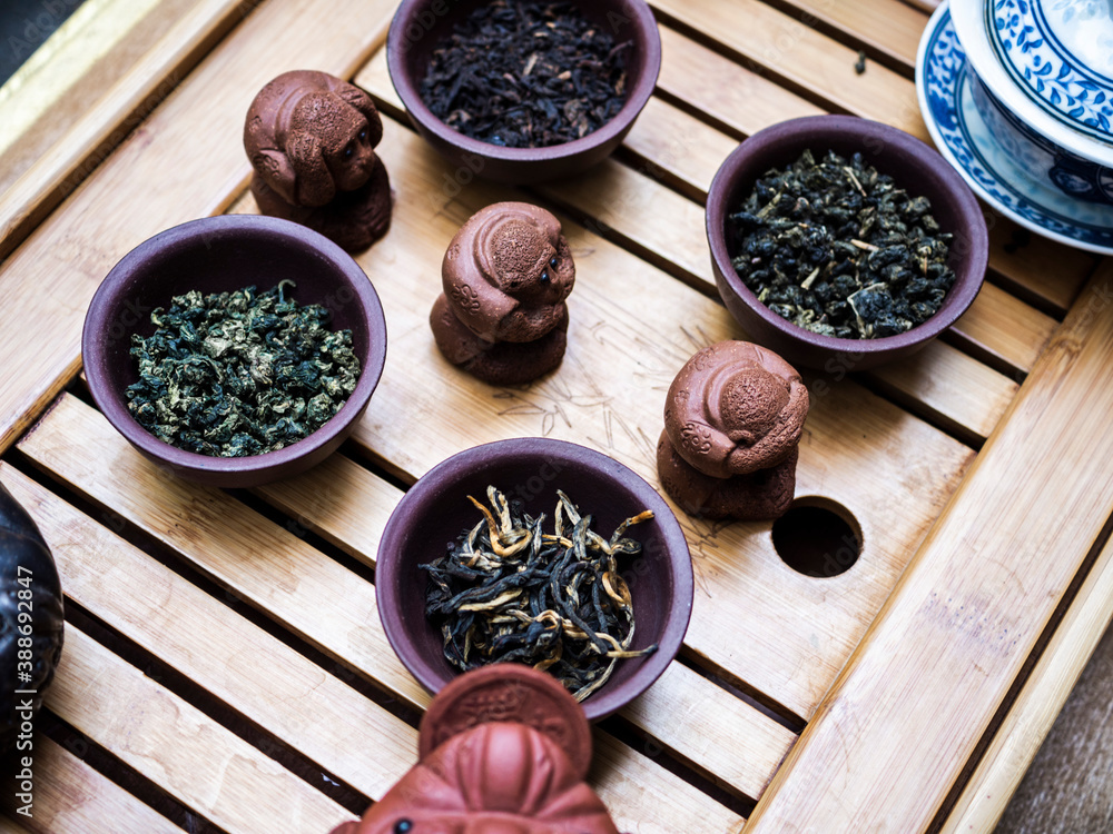 Assortment of Chinese tea in clay bowls on a wooden table Assortment of Chinese tea in clay bowls on a wooden table