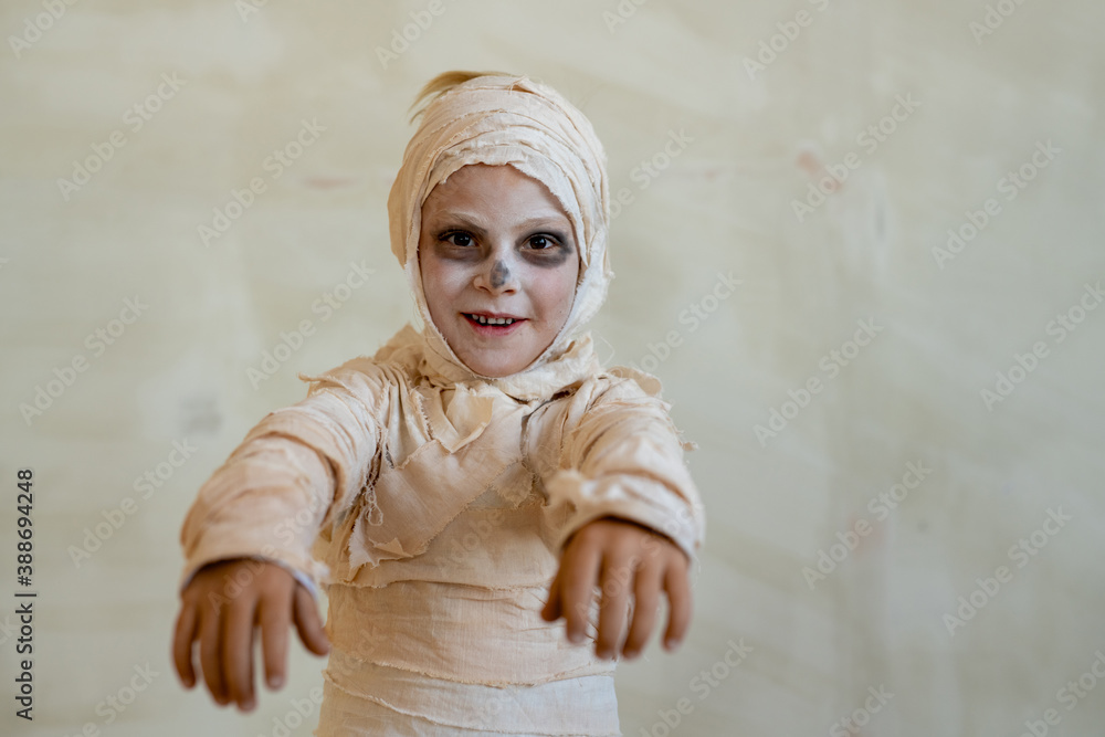 Portrait of positive boy in mummy costume made of bandages acting like zombie at Halloween party Portrait of positive boy in mummy costume made of bandages acting like zombie at Halloween party