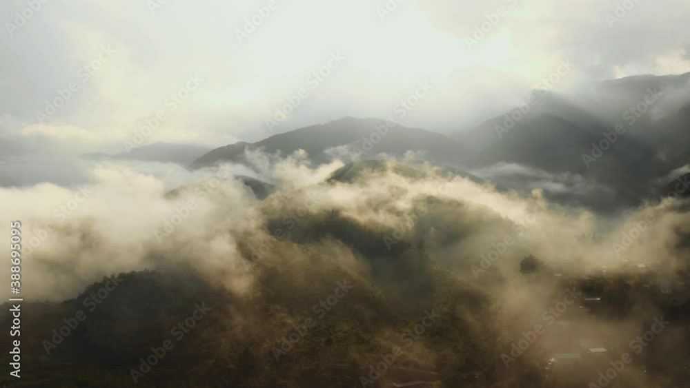 Aerial sunrise landscape above mountains with moving cluds and fog Aerial sunrise landscape above mountains with moving cluds and fog