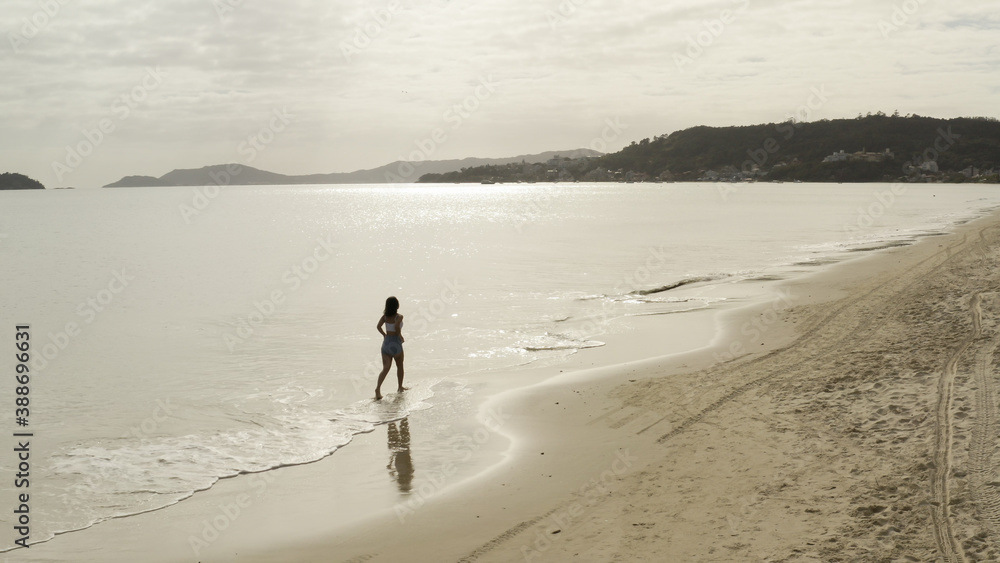 Naklejka premium Beautiful girl walking along the beach, aerial footage from Florianópolis Santa Catarina Brazil