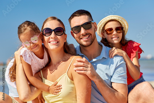 family, leisure and people concept - happy mother, father and two daughters on summer beach © Syda Productions
