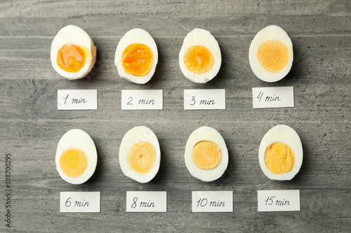 Boiled eggs and labels with cooking time on gray background