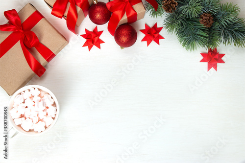 New Year's gifts with a red bow, a fir branch, a cup of coffee with marshmallows on a light background. Flat lay, top view, copy space for text. Christmas festive composition.