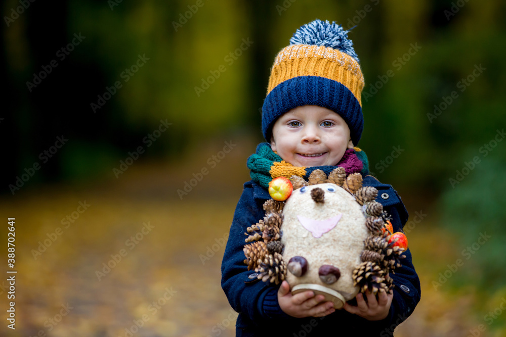 Cute toddler child, boy, playing in park on sunny autumn day Cute toddler child, boy, playing in park on sunny autumn day