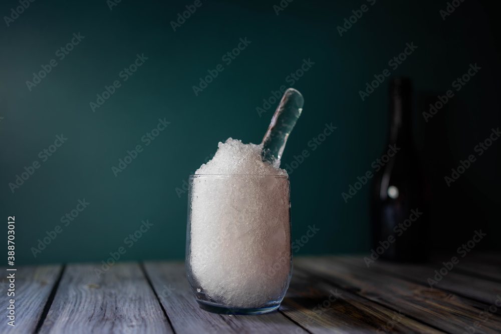 crystal glass with very fine crushed ice on wooden table