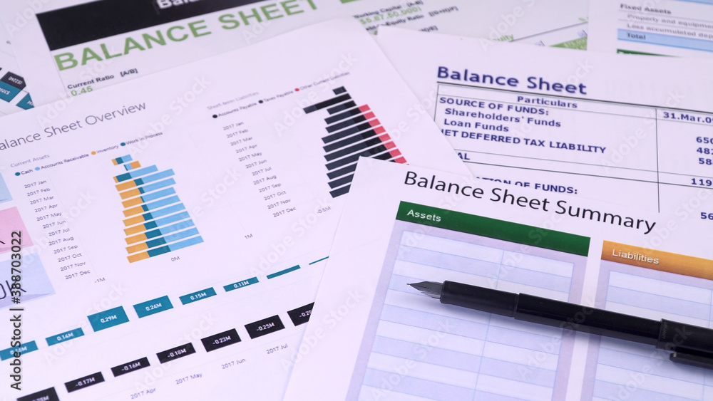 Conceptual composition. Balance sheet summary form and pen on the background of financial documents, close-up Conceptual composition. Balance sheet summary form and pen on the background of financial documents, close-up